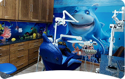Paediatric dentist chair with cartoon shark in the background